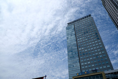 Low angle view of modern building against cloudy sky