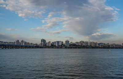 Scenic view of sea by buildings against sky