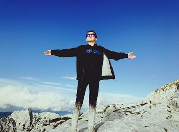 Low angle view of man standing on snow against sky