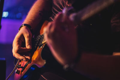 Midsection of man playing guitar