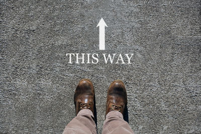 Low section of man standing on road