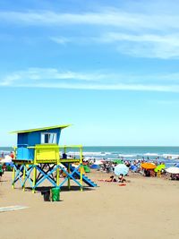 Lifeguard hut on beach against blue sky