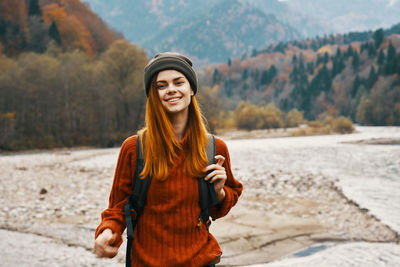 Portrait of smiling young woman standing outdoors