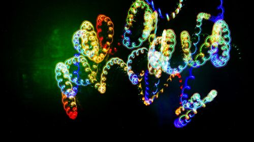 Close-up of illuminated christmas lights against black background