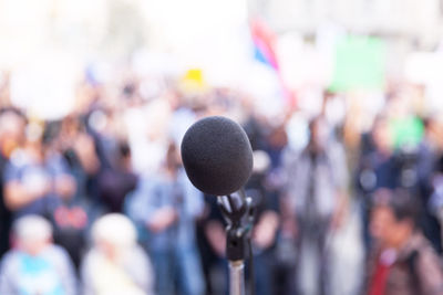 Close-up of microphone with people in background