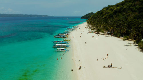 Sandy tropical beach with tourists and blue clear sea. boracay, philippines.puka shell beach