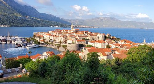 High angle view of townscape by sea against sky