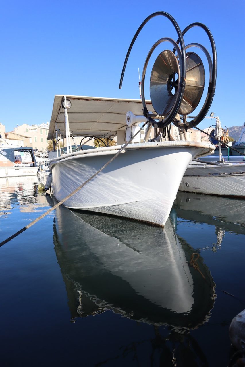 BOAT MOORED AT HARBOR AGAINST CLEAR SKY