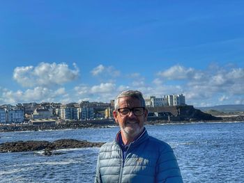 Portrait of man standing against sky