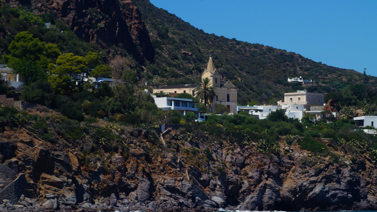 VIEW OF VILLAGE AGAINST MOUNTAINS