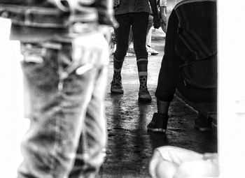 Low section of people standing on tiled floor