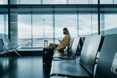 Portrait of young woman sitting on escalator