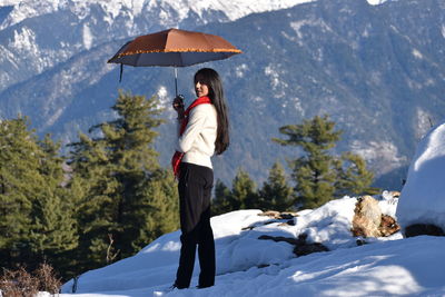 Woman standing on snow covered mountain