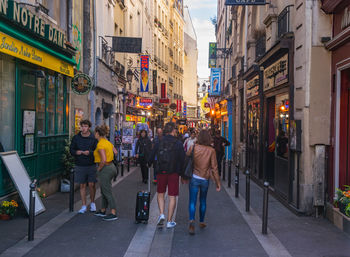 People walking on city street amidst buildings