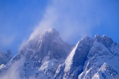 Scenic view of snowcapped mountains against blue sky