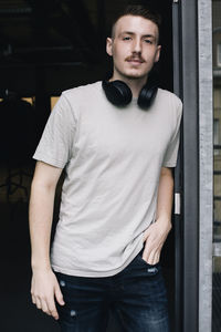 Portrait of male programmer with wireless headphones around neck in office