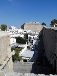 Houses in town against clear blue sky