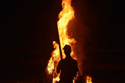 Silhouette of man with fire crackers at night