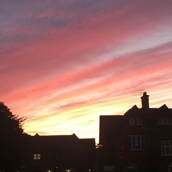 Silhouette buildings against sky at sunset