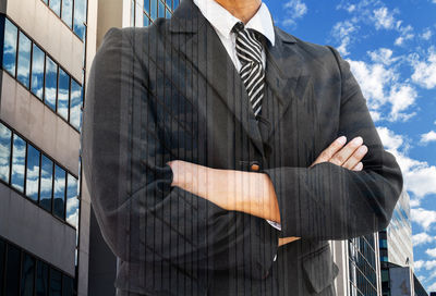 Digital composite image of businessman and building against sky