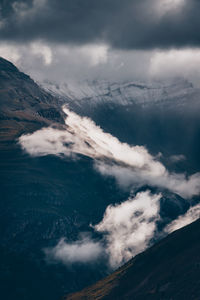 Low angle view of snowcapped mountains against sky