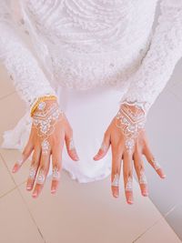 Low section of bride wearing dress and jewelry during wedding ceremony