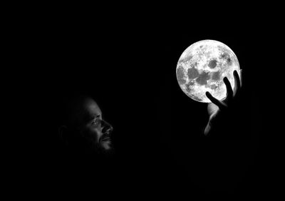 Digital composite image of man holding moon