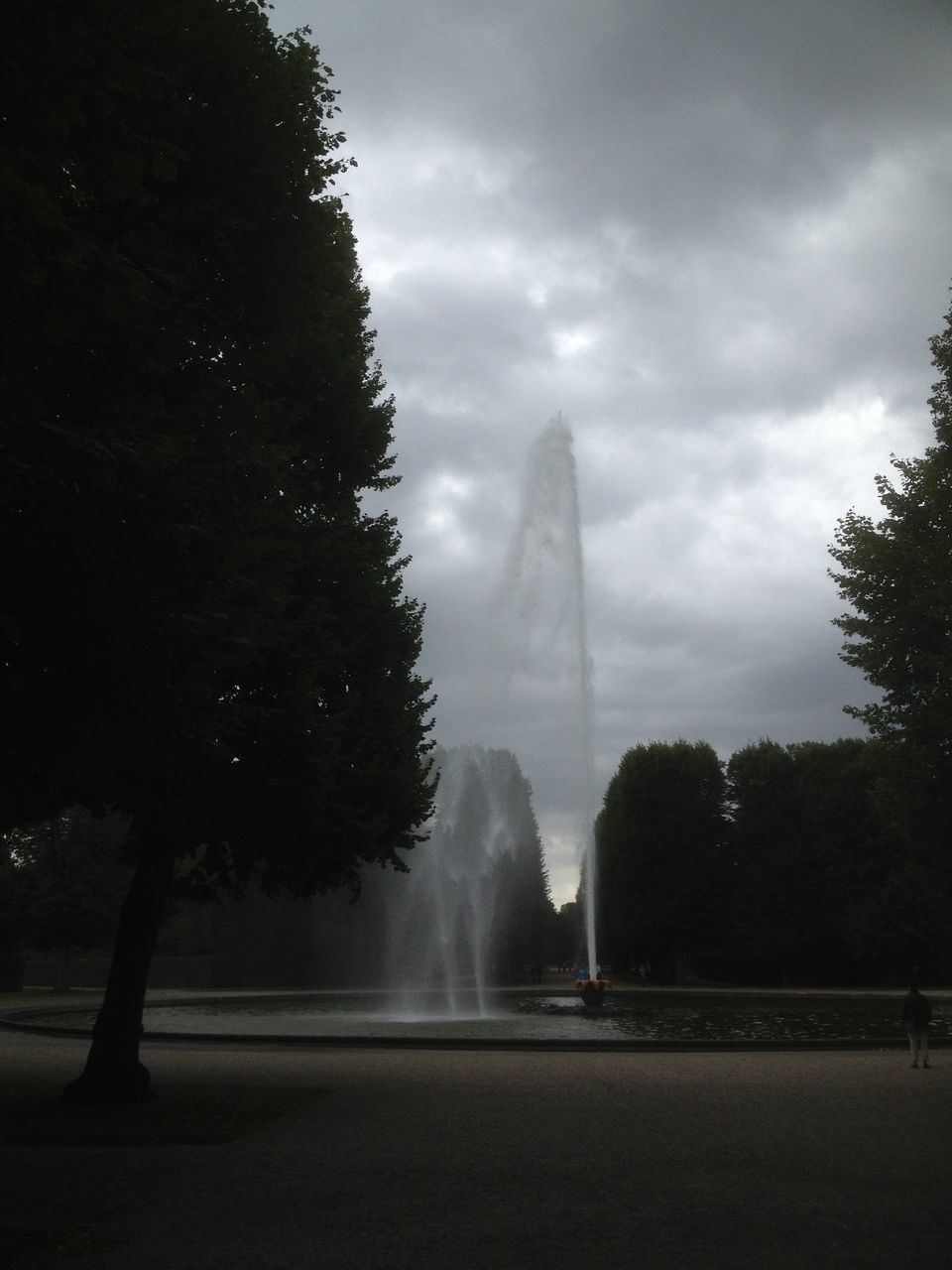 tree, sky, built structure, architecture, famous place, travel destinations, cloud - sky, fountain, park - man made space, tourism, building exterior, weather, international landmark, travel, cloudy, nature, city, outdoors, incidental people, day