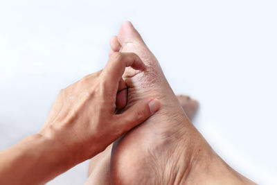 Close-up of hand touching finger against white background