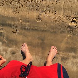 Low section of man standing at beach