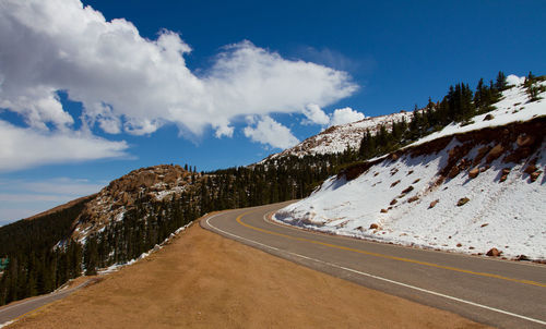 Road amidst snowcapped mountains against sky