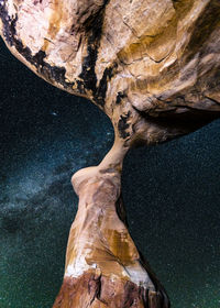 Low angle view of rock formations against star field