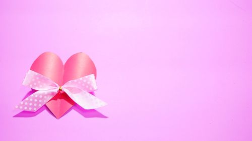 Close-up of heart shape made on pink background