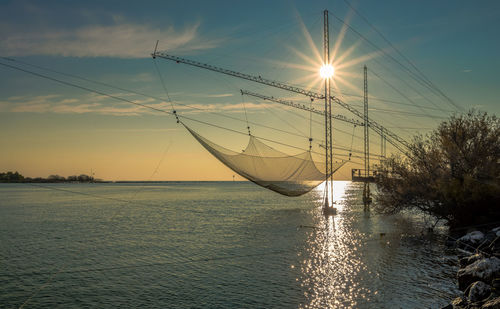 Sailboat in sea against sky during sunset