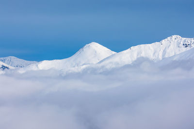 Scenic view of snowcapped mountain against blue sky