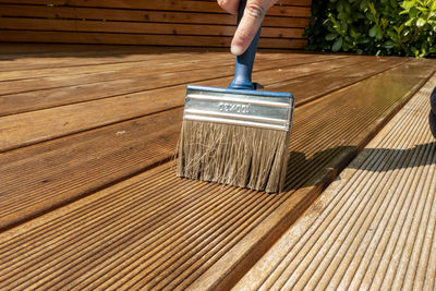 Low section of person holding umbrella on wooden floor