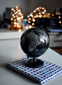 Close-up of globe and spiral notebook on table