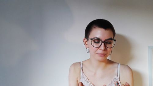 Portrait of a young woman against wall