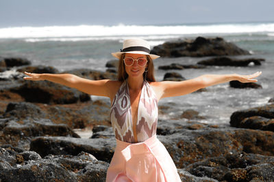 Young woman standing on rock at beach