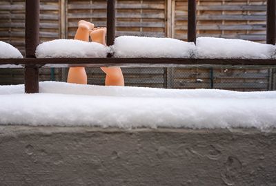 Low section of person with snow on retaining wall