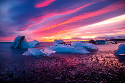 Scenic view of frozen landscape against sky during sunset