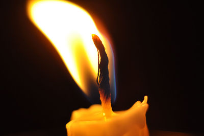 Close-up of lit candle in dark room