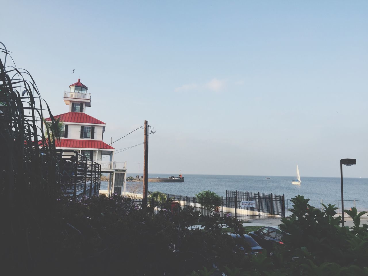 sea, horizon over water, water, beach, protection, built structure, lighthouse, safety, tranquil scene, tranquility, sky, architecture, shore, scenics, security, clear sky, nature, beauty in nature, guidance, building exterior