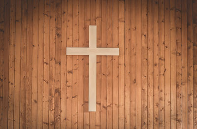 Close-up of cross on wooden wall