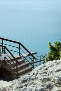 High angle view of staircase by sea against sky