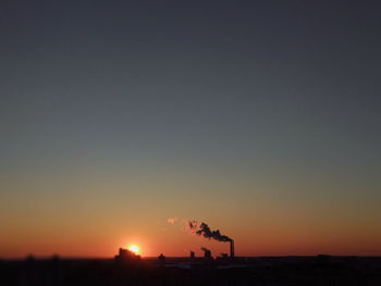 Silhouette landscape against clear sky during sunset