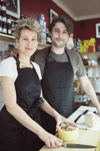 Portrait of confident workers at counter in supermarket