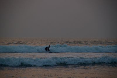 Man is serfing against clear sky during sunset in goa