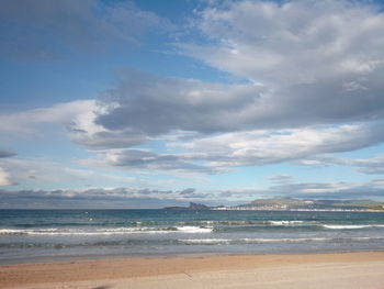Scenic view of beach against cloudy sky