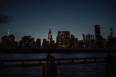 Illuminated buildings in city against sky